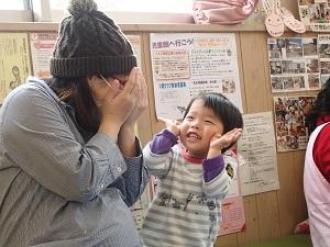 親子でいないいないばあっ！の遊びをしており、男の子が満面の笑みで「ばあっ」と顔の横で両手を広げている写真