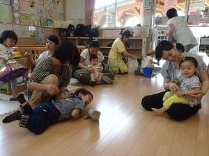 床に寝そべっている子どもや母親の膝の上に座っている子供たちの写真