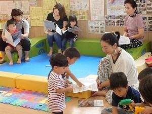 子供と一緒に資料を見ている母親たちの写真