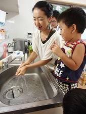 母親が子供に手洗いの方法を実践して教えている写真