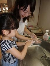 母親と女の子が一緒に手を泡立てている様子の写真