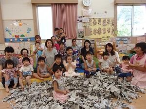 ビリビリに破いた新聞紙を前に、参加した親子が集まっている集合写真