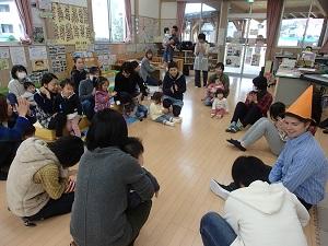円を描くように丸くなって座って話をしている英語の先生と親子の写真
