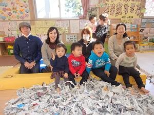 びりびりに破いて山積みになった新聞紙の後ろに参加者の親子が笑顔で写っている集合写真