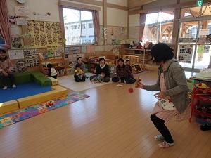 けん玉に挑戦する職員の方を皆で見守っている写真