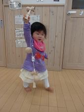 糸が絡まったけん玉を持ち高く掲げる子供の写真