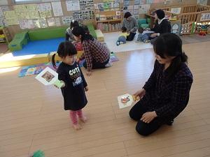 アンパンマンのイラストが貼られた羽子板を持っている親子の写真
