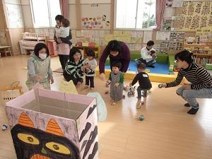 鬼の描かれた段ボールにマメボールを投げ入れる子供たちの写真