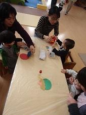 画用紙を使って鬼を作る親子たちの写真