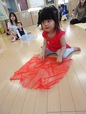 赤いスカーフを床に敷く子供の写真