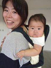 上手く抱っこ紐で赤ちゃんを背負うことが出来た笑顔の母親の写真