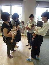 4名の母親が円になって、それぞれ赤ちゃんを両手で抱っこしている写真