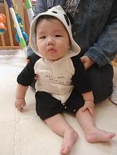 パンダのロンパースを着ている赤ちゃんの写真