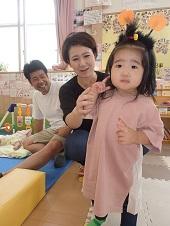 ピンク色のワンピースを着ている女の子と母親と父親の写真