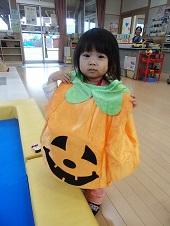 ジャックオーランタンのかぼちゃのコスチュームを着ている女の子の写真