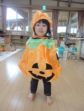 ジャックオーランタンのかぼちゃのコスチュームと帽子をかぶっている女の子の写真
