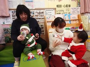 クリスマスツリーの衣装を着た赤ちゃんとサンタの衣装を着た子供がプレゼントを貰った写真
