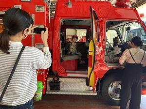 消防車に乗る子どもと写真を撮る母の様子