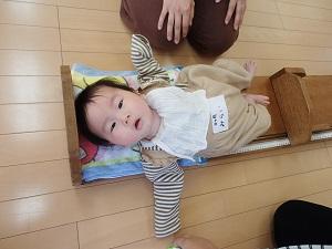 寝転びながら身長測定をしている赤ちゃんの写真