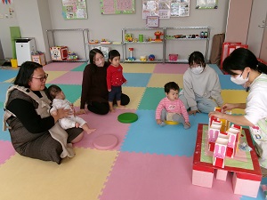 牛乳パック制作の説明を聞く親子たち