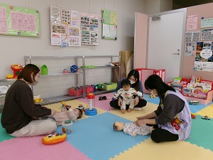 ふれあい遊びをする先生と親子たち