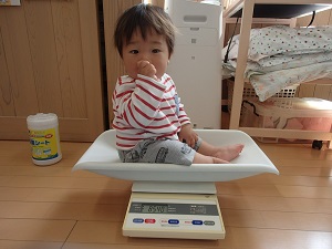 体重を測る乳児