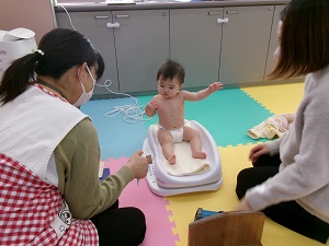 体重を測る乳児