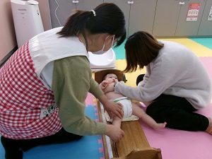 身長を測る乳児