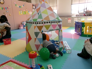 ボールプールのテントにはいはいで入っていく幼児