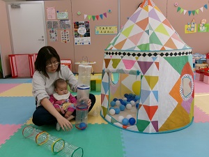 ボールをペットボトルに入れて遊ぶ親子