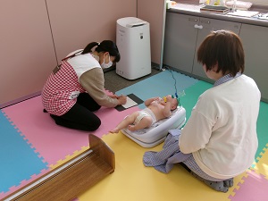 体重を測る乳児