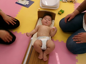 身長を測り終わった乳児