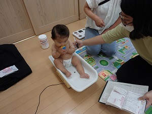 体重計に座っている乳児