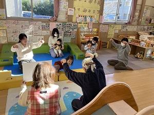 先生と一緒に手話をする親子たち