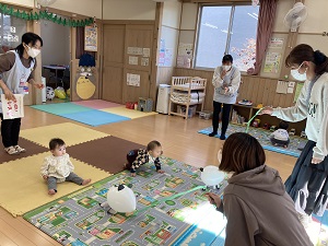 どうぶつ風船ではいはいを誘う母とはいはいする乳児