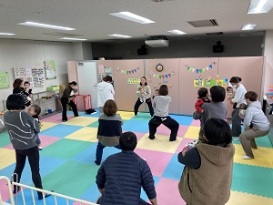 赤ちゃんを抱きながらスクワットをする親子たち