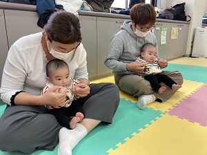 赤ちゃんの手のひらをマッサージする父母