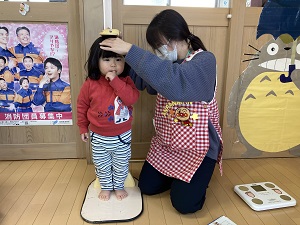 身長を測ってもらう幼児