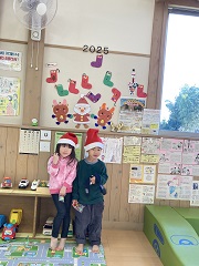 サンタさんの帽子をかぶり記念撮影する幼児たち