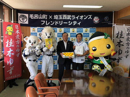 埼玉西武ライオンズのマスコットキャラクター2体と町長、居郷 肇社長が記念撮影をしている写真