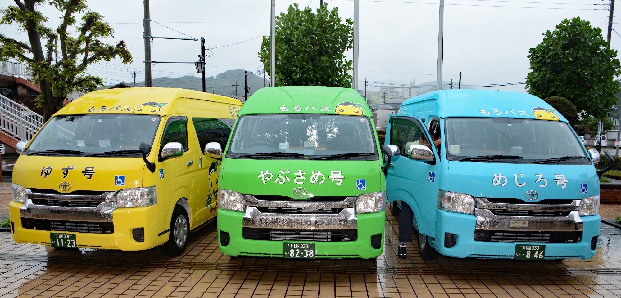 左から正面を向いている黄色の「ゆず号」、黄緑色の「やぶさめ号」、水色の「めじろ号」の町内循環バス（もろバス）の写真